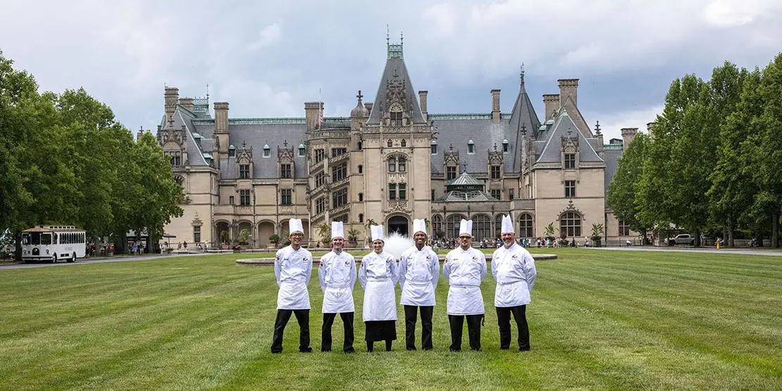 six chefs standing on a lawn in front of the Biltmore House