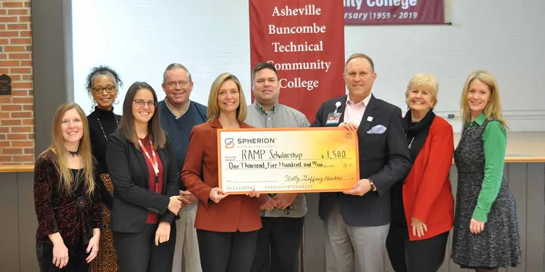 A group of smiling people with an oversized check