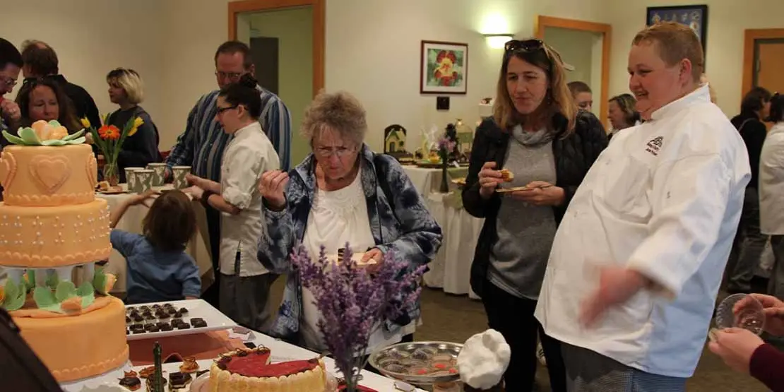 Baking chef at table with two women 