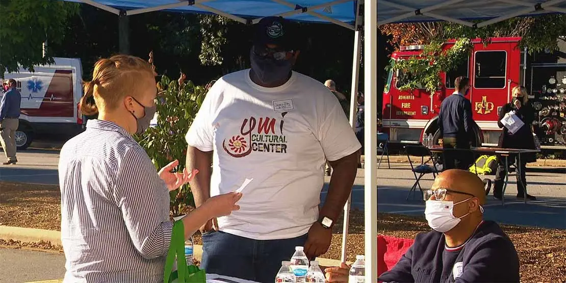 Two men behind a table talking to a client