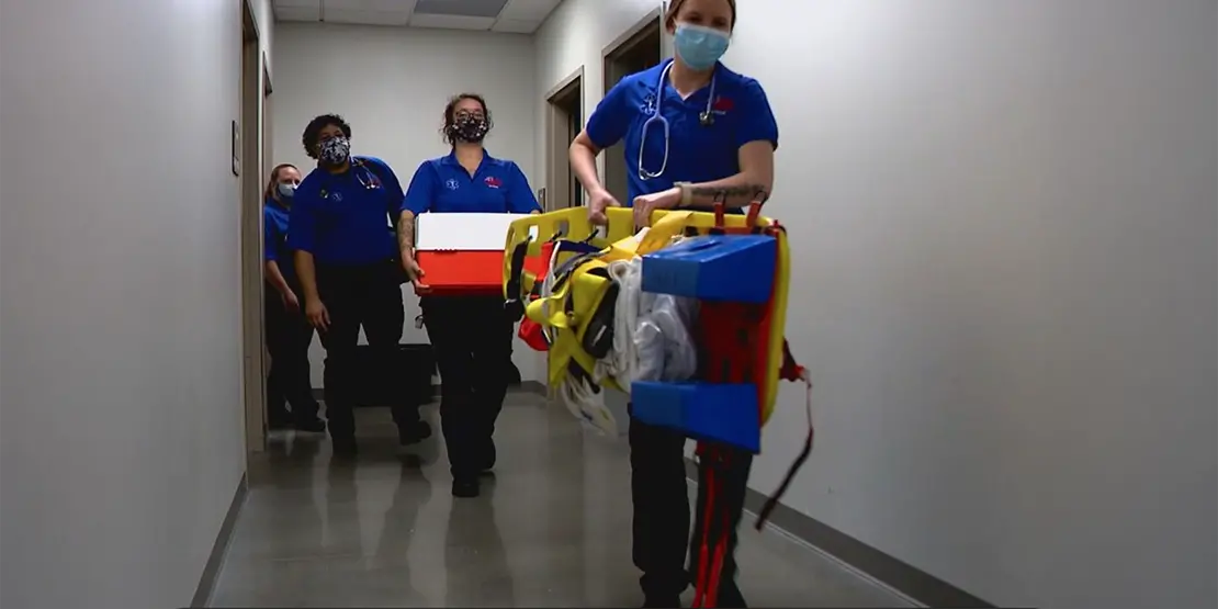 EMS students with equipment in a hallway
