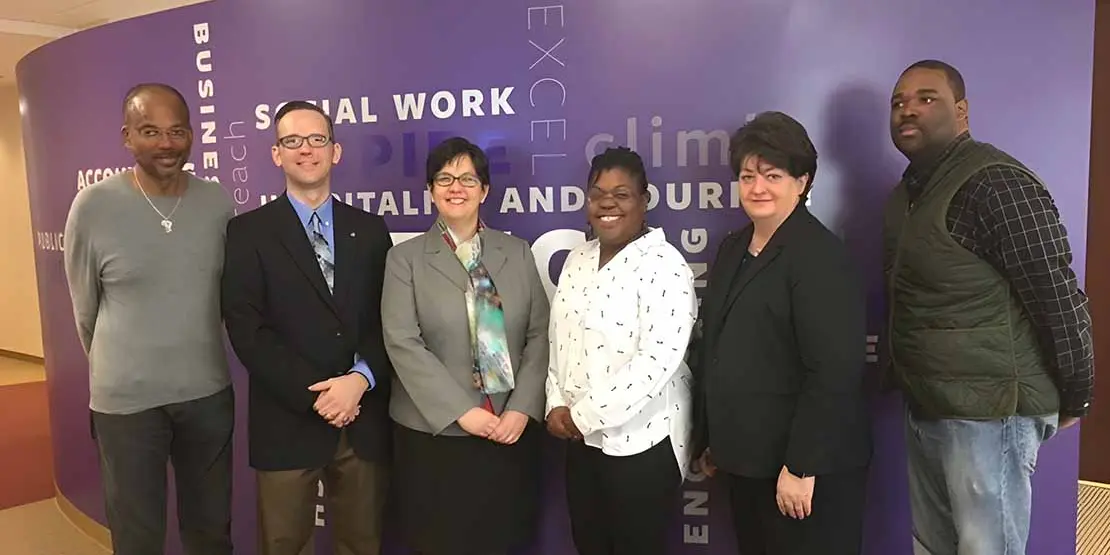 Six men and women standing together