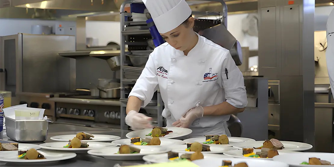 Student chef preparing plates of food.