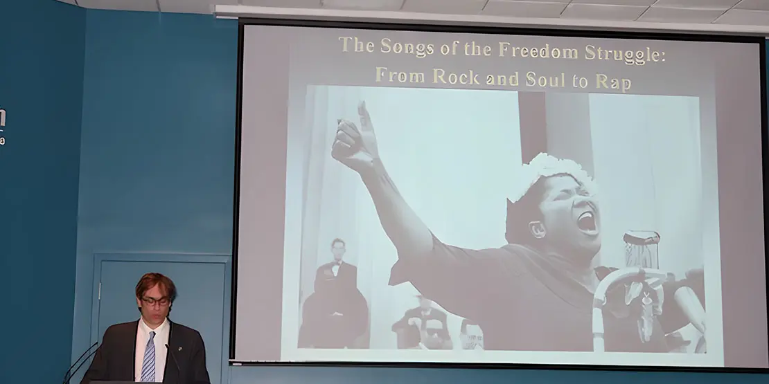 David Gilbert standing in front of a screen