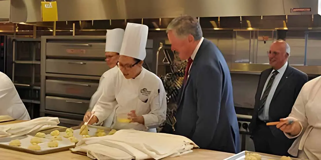 Mark Meadows at counter talking to a  Baking and Pastry Arts student