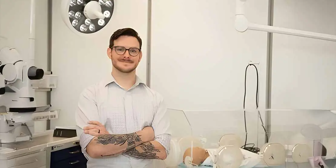 Man in white shirt standing in a simulated hospital environment