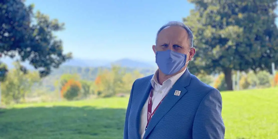 Dr. John Gossett standing outside wearing a blue face mask