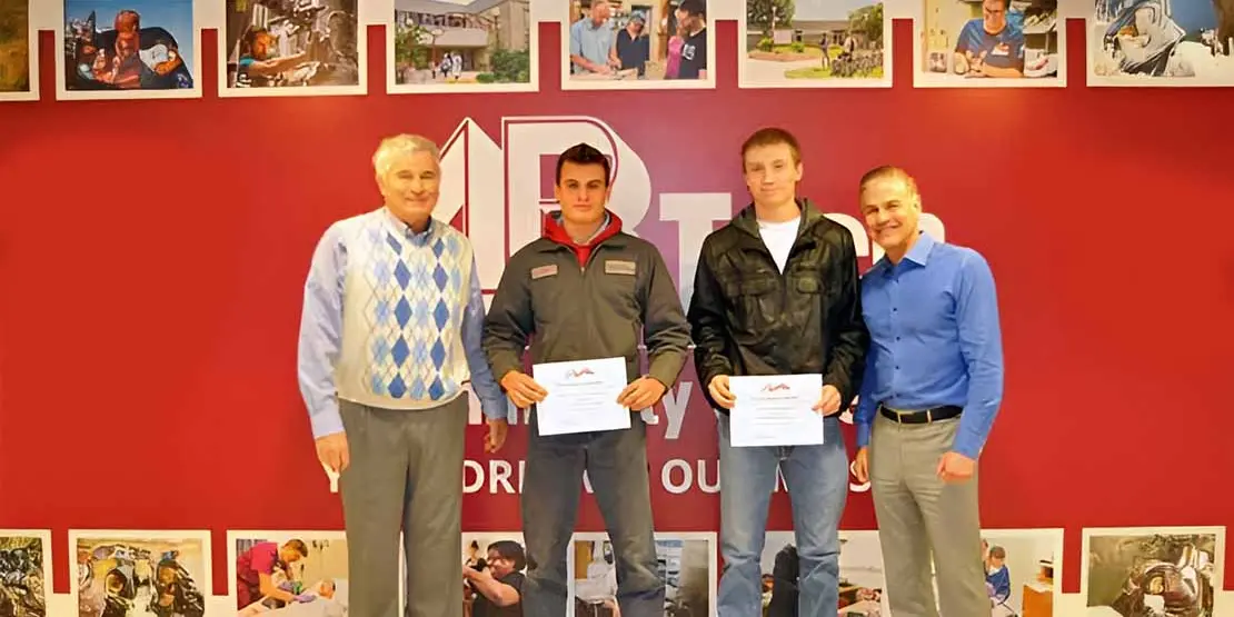 Gentry Heating President and three Gentry Heating Scholarship recipients standing in front of a wall