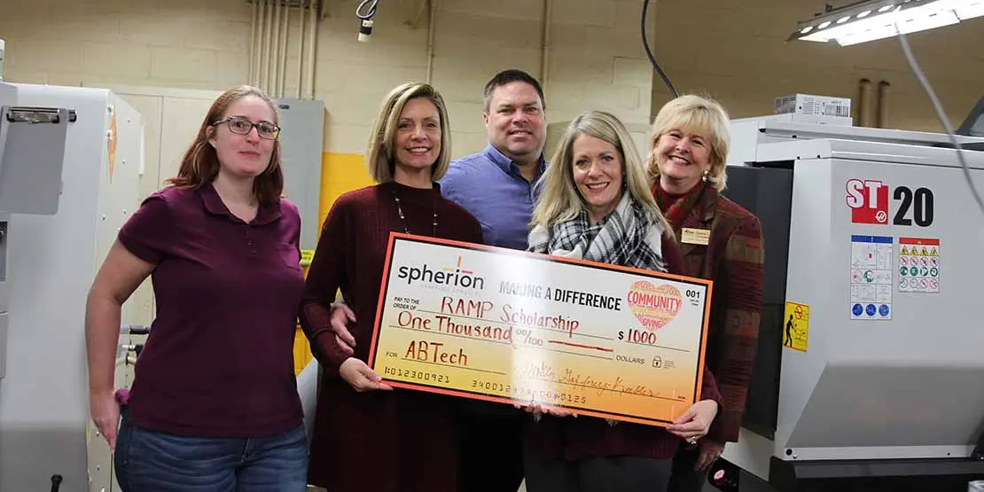 Five people with a giant check