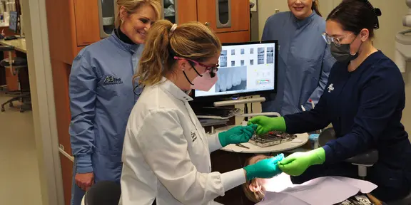 Dental Assisting with students and dentist/Instructors