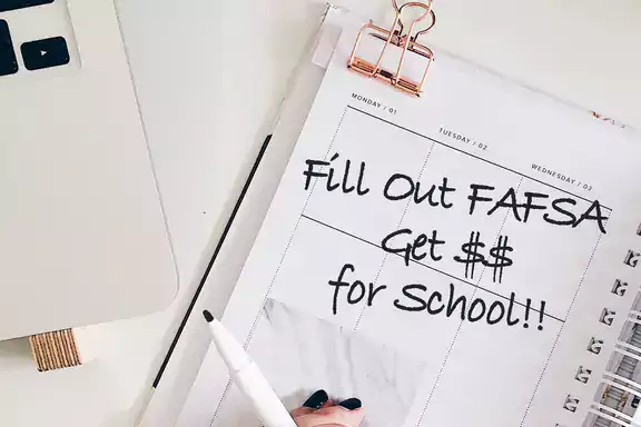 Calendar/Date book with the words "Fill Out FAFSA get $$ for school" written on it.