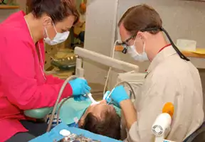 dentist and student working on client