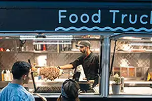 Two people looking into a food truck