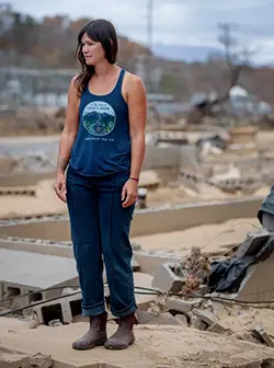 Jessie Dean, founder of Asheville Tea Company, stands among the ruins of her production facility and office along the Swannanoa River in Asheville, October 31, 2024.