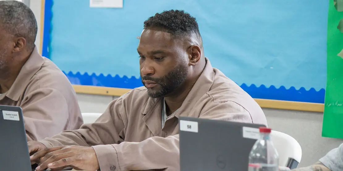 Brandon Swindell, a student at Nash Correctional Institution, types on his laptop. Ben Humphries/EdNC