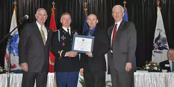 Four men in uniform on a stage