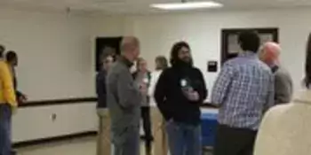 People standing in a circle with beverages in their hands.