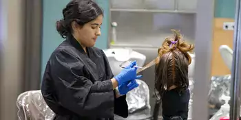 A woman working on a head of hair