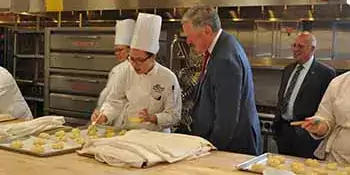 Mark Meadows at counter talking to a Baking and Pastry Arts student