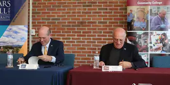 Dennis King and Tony Floyd signing a document