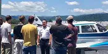 A-B Tech Aviation student with a group of people in front of a plane.