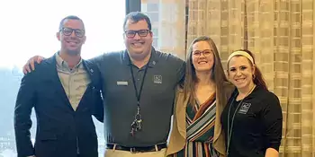 Two men and two women standing in a row