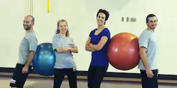 Four people with two large playground balls