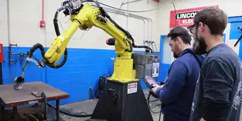 Two men working with a robit