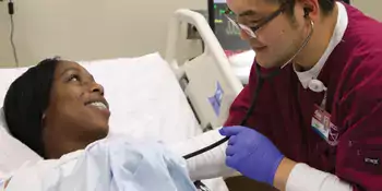 Nursing student and patient smiling