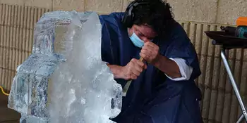 Man using chisel on a block of ice