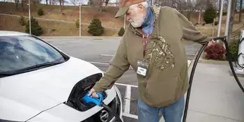 Man putting charger on electric car