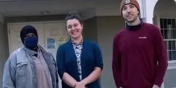 Three students standing in front of a white building