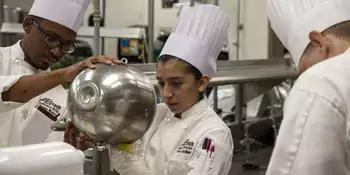 Three chefs using a mixer