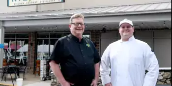 Man and chef in front of distillery