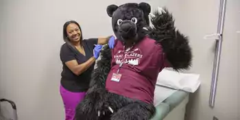 Trailblazer Bear receiving a vaccine from the health clinic