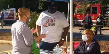 Two men behind a table talking to a clinet