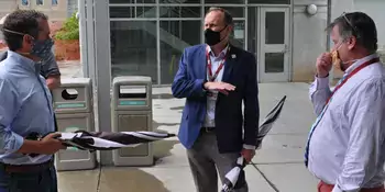 Three men wearing masks and talking