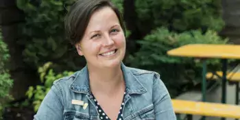 Woman sitting at a picnic table with a beer