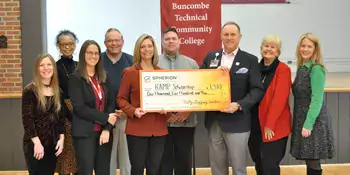 A group of smiling people with an oversized check