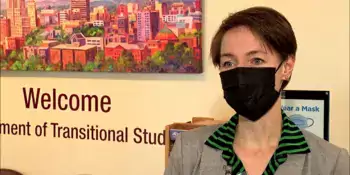 Woman in face mask standing in front of a wall