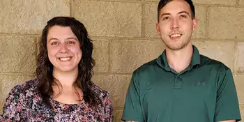 Woman and man standing in front of a wall