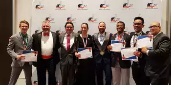 Eight people in formal wear standing in front of a wall with ACF logos