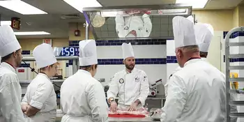 Chef standing behind table with 5 students watching