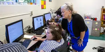 SOAR teacher helping a student at a computer