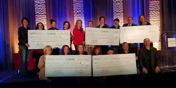 Winners posing with check