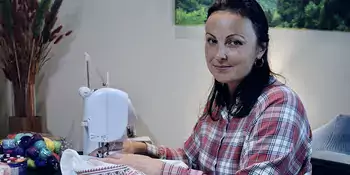 Nataliia Chorna sitting at sewing machine