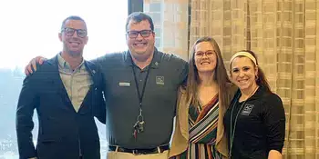 Two men and two women standing in a row