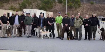 Handlers and their dogs standing outside