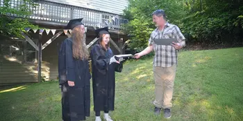 High School Handoff: Claire Bowling, left, and Amelia Darnell receive their high school diplomas in July 2019 from Chuck Bowling, who served as principal of their home school, Parkview Academy. Photo by Roger Darnell