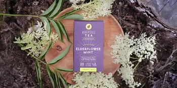 Box of tea sitting beside white flowers
